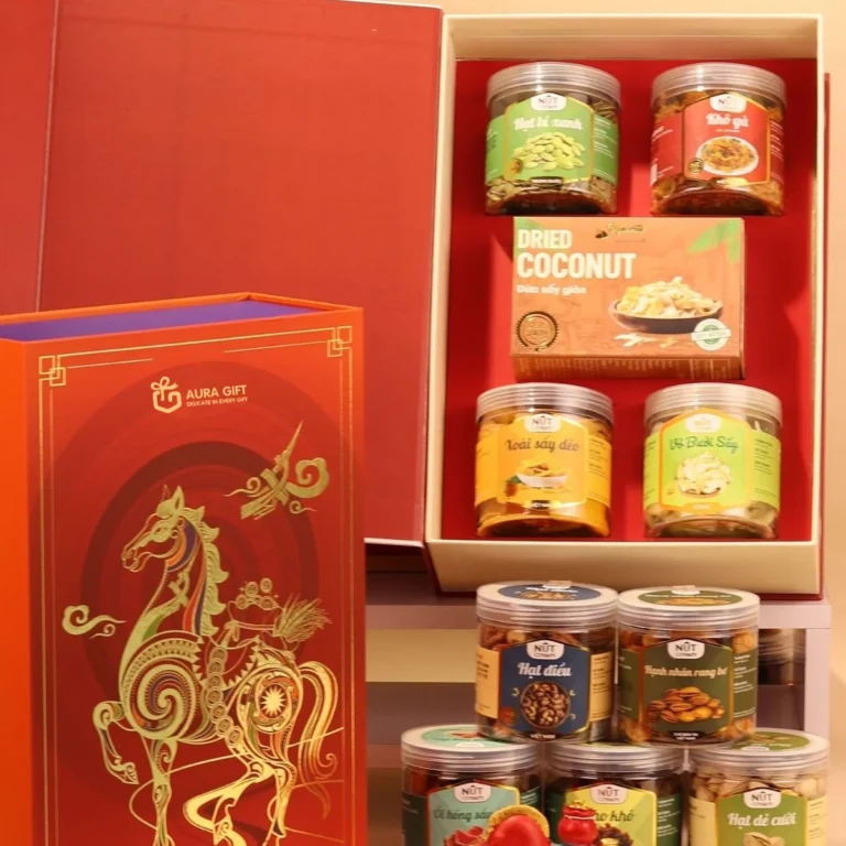 Hộp quà Tết đỏ ép kim ngựa cạnh hộp mở chứa hũ hạt, xoài sấy, dừa sấy, khô gà