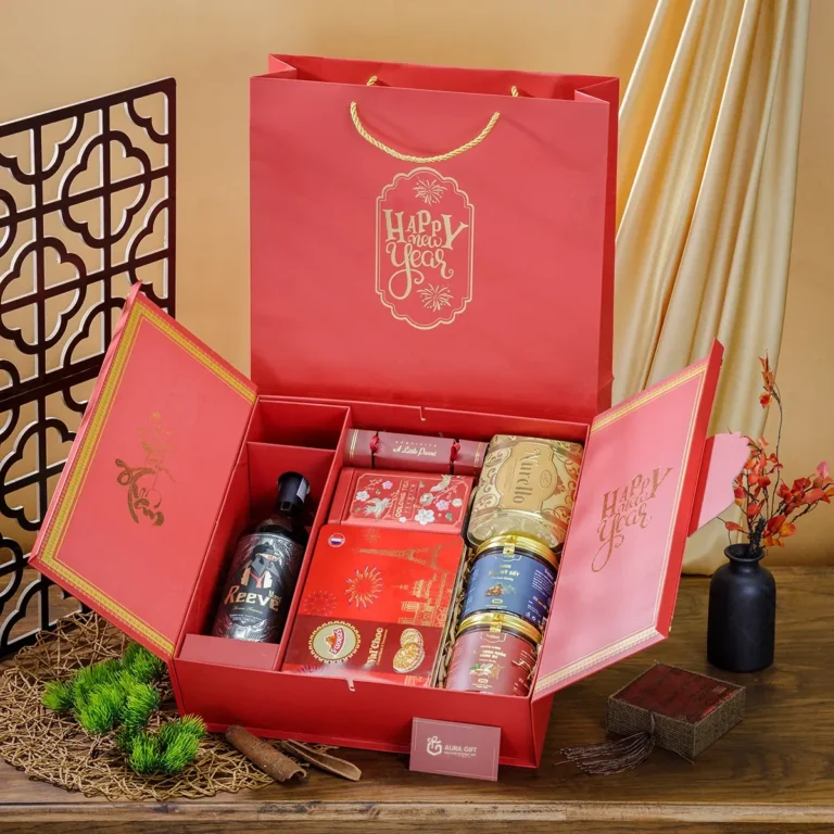 Hộp quà Tết 2 cánh đỏ mở ra, ngăn rượu vang, bánh quy thiếc, trà, hũ hạt; túi đỏ ép kim