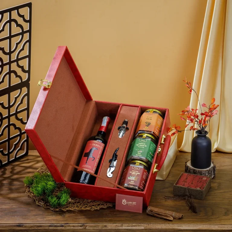 Vali hộp quà Tết da đỏ mở, lót nỉ nâu, ngăn rượu vang, bộ khui rượu và 3 hũ hạt