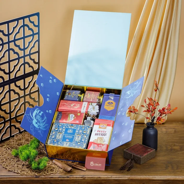 Hộp quà Tết 2 cánh xanh lam mở, lòng ánh kim vàng đựng bánh quy thiếc, trà, kẹo, bánh bơ